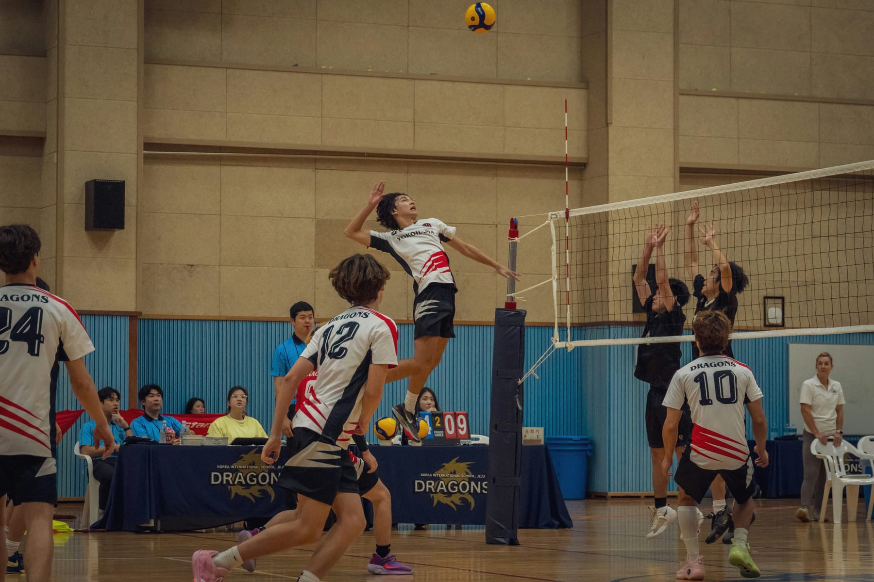A hitter in the air at the net, arm back, about to swing
